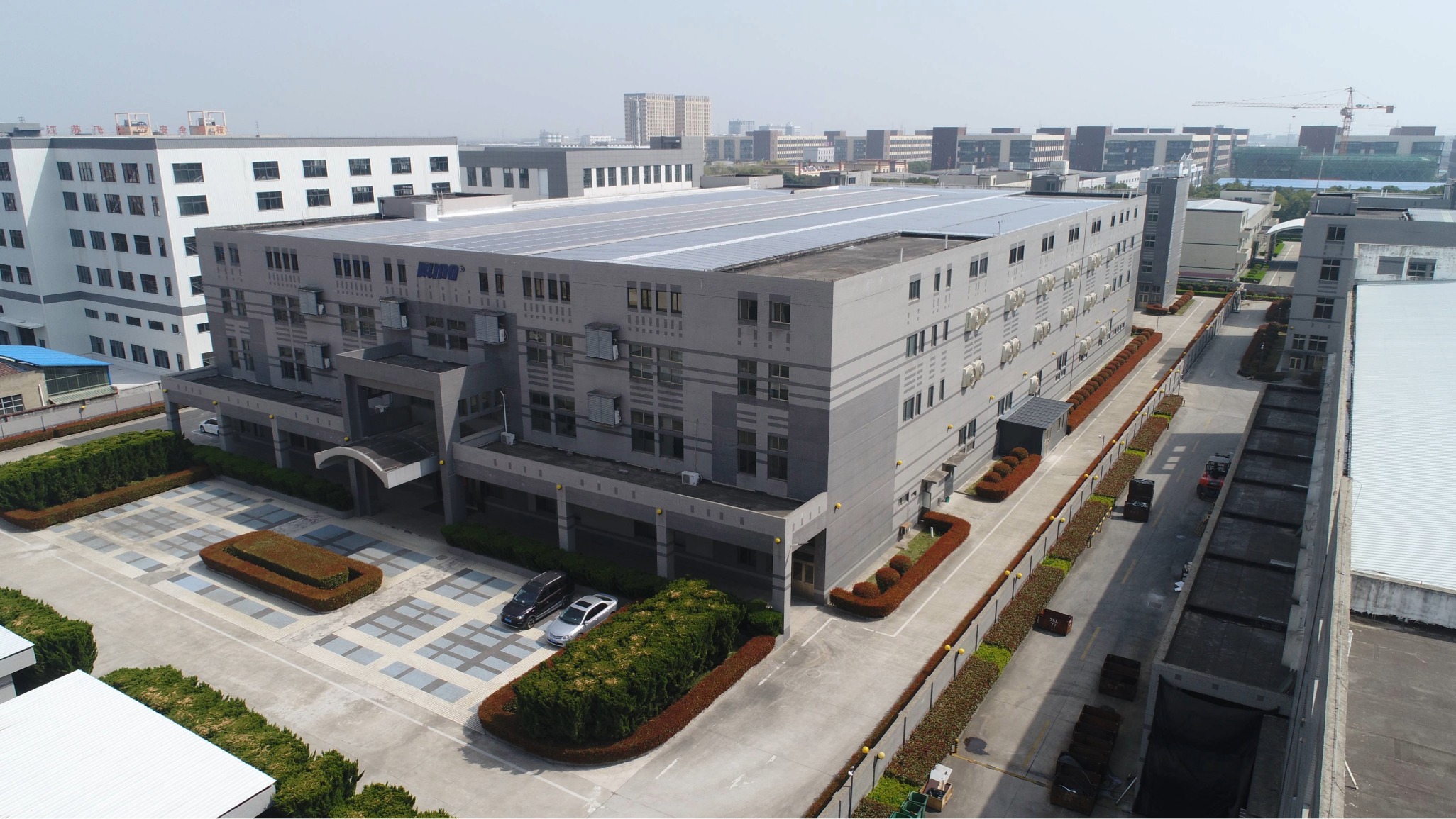 Aerial view of KUPO's 17,098 square meter manufacturing facility in Taizhou, China, featuring rooftop solar panels